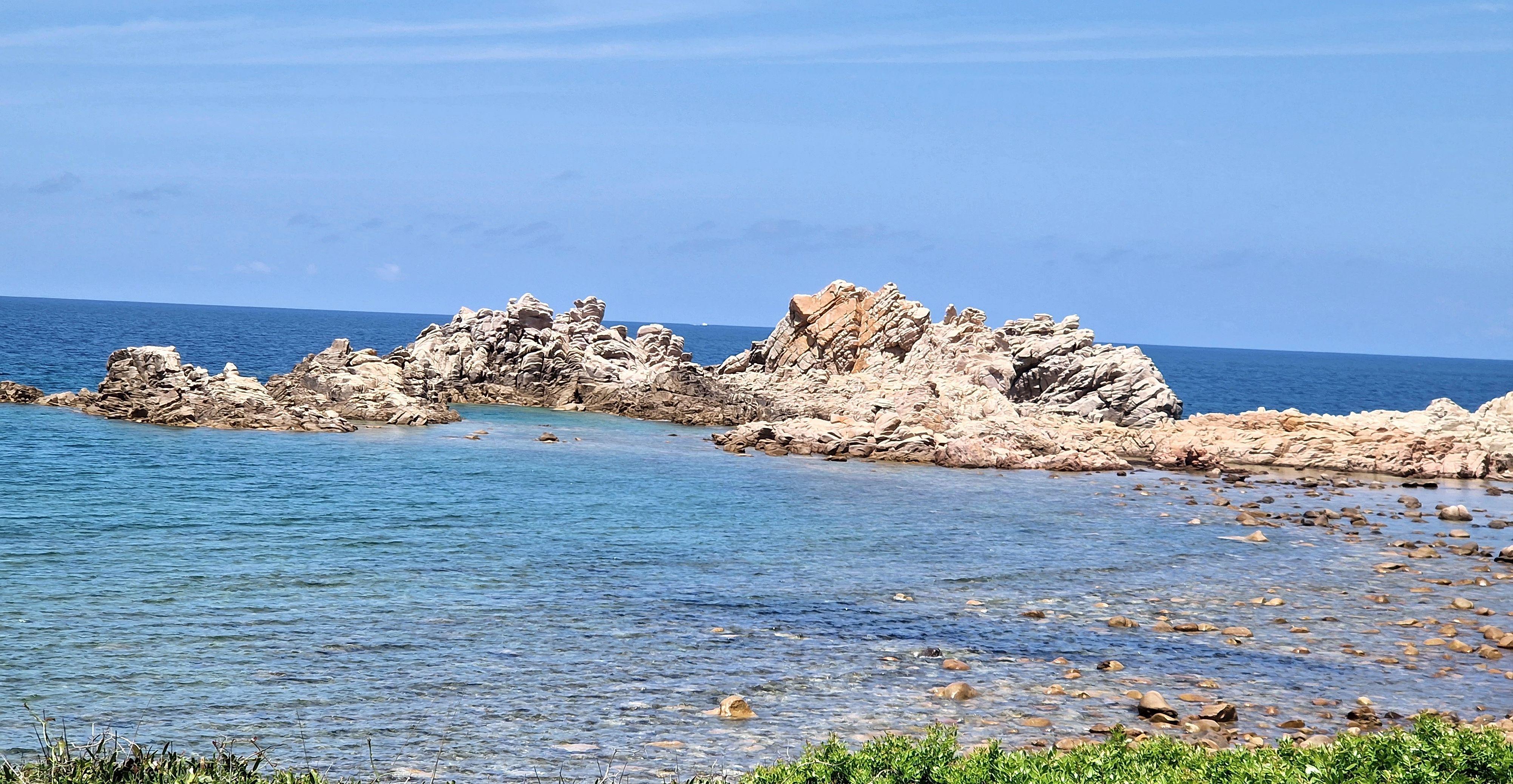 Paesaggio costiero con formazioni rocciose e mare cristallino a Isola Rossa